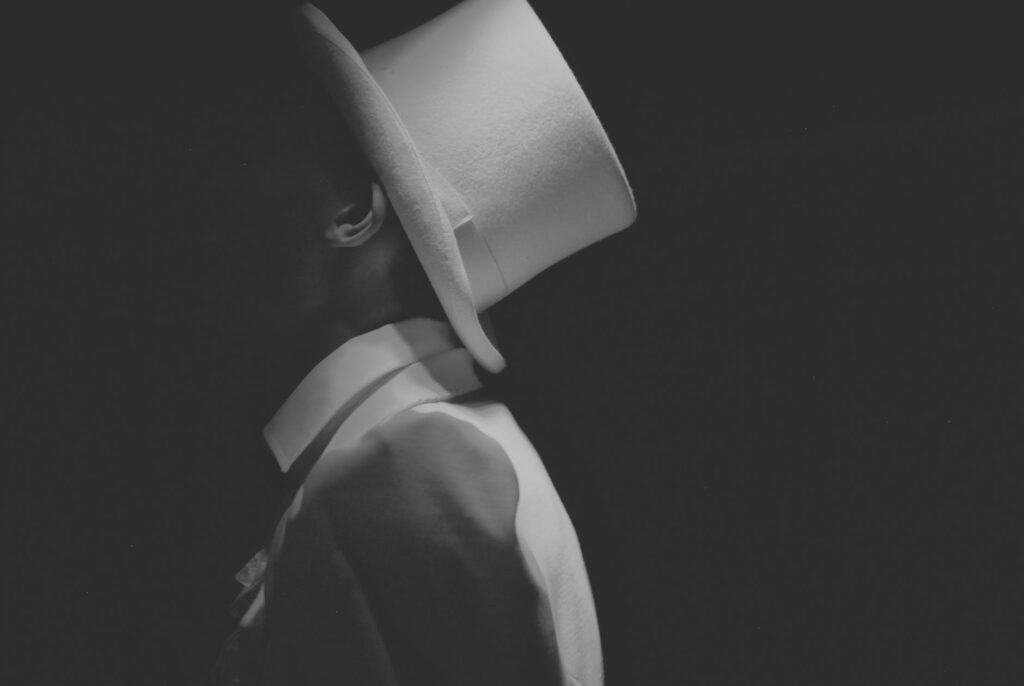 man wearing white hat greyscale photography
